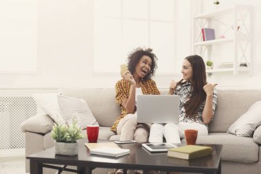 Kredi kartı ve dizüstü bilgisayar ile iki kadın online