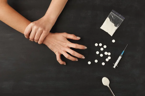 Mãos viciadas em drogas na mesa escura — Fotografia de Stock