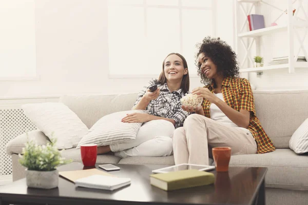 Smiling female friends watching TV at home — Stock Photo, Image