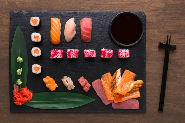 Sada různé sushi, maki a rohlíky na rustikální dřevěné pozadí — Stock fotografie