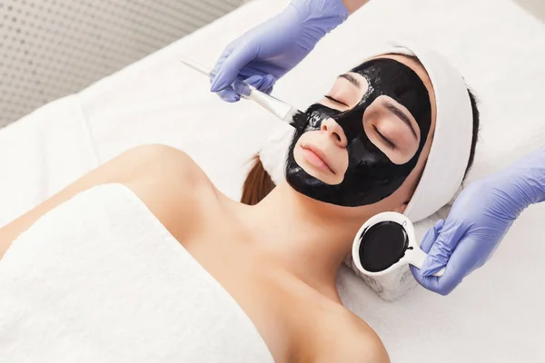 Mujer recibiendo máscara facial por esteticista en el spa — Foto de Stock