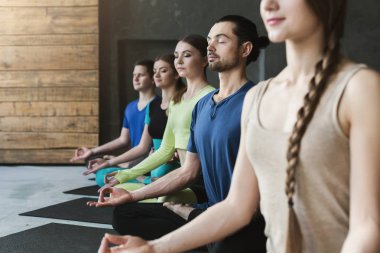 Genç kadın ve erkek yoga sınıfındaki rahatla meditasyon poz