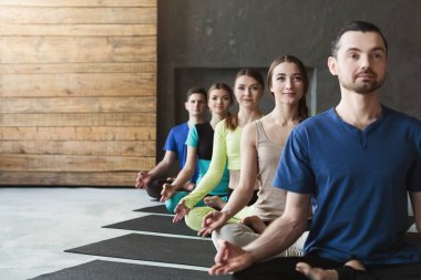 Genç kadın ve erkek yoga sınıfındaki rahatla meditasyon poz