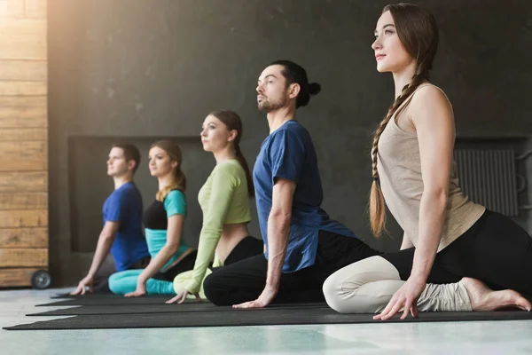 Jeunes femmes et hommes en cours de yoga, pose de méditation relaxante — Photo