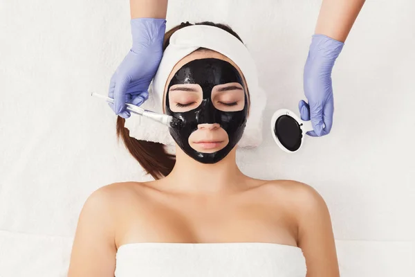 Woman getting face mask by beautician at spa — Stock Photo, Image