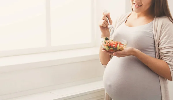 Young pregnant woman eating fresh green salad — Stock Photo, Image