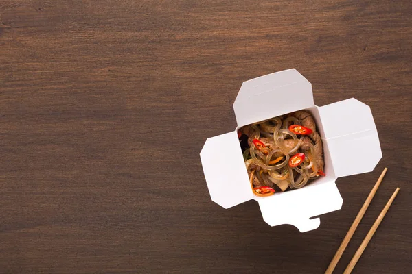 Funchoza-Salat in Pappschachtel auf Holztisch — Stockfoto