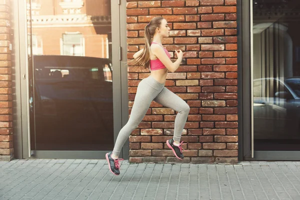 Young woman jogging in city copy space — Stock Photo, Image