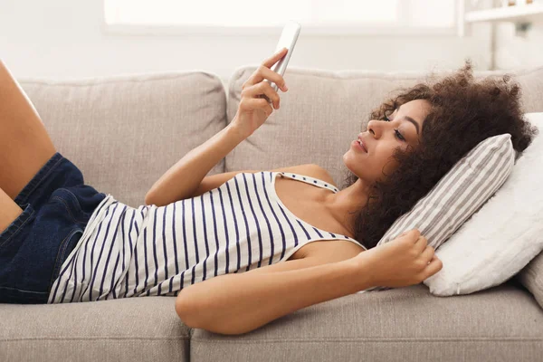 Jong meisje met behulp van mobiele telefoon op Bank — Stockfoto