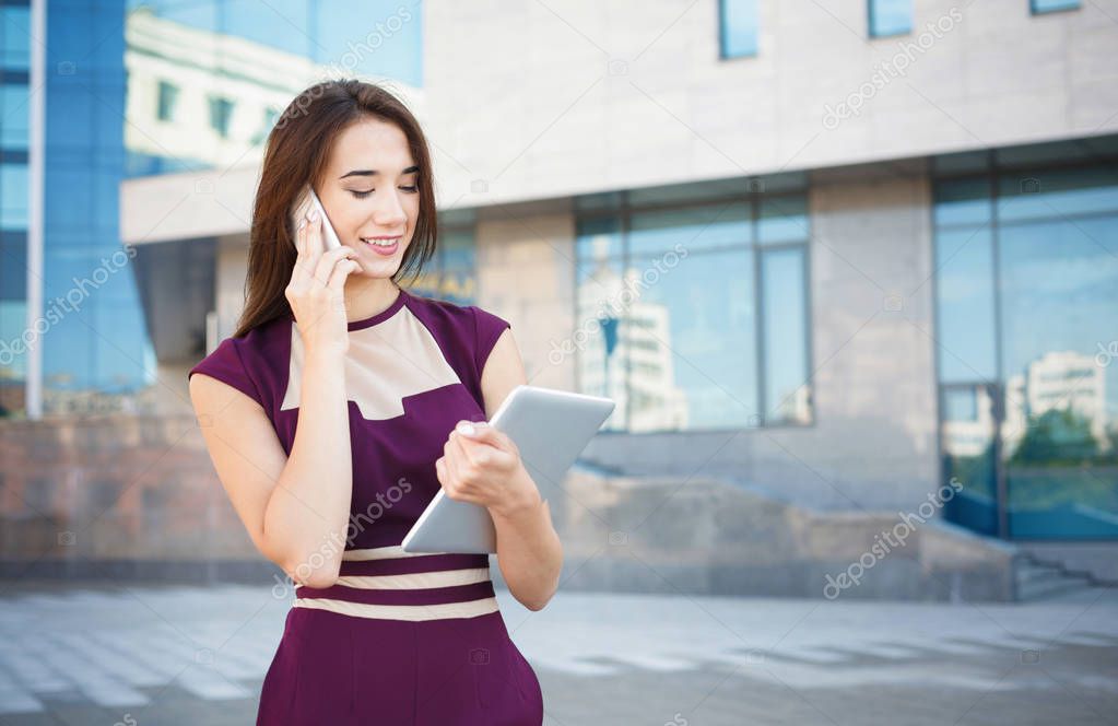 Happy businesswoman talking on smartphone outdoors