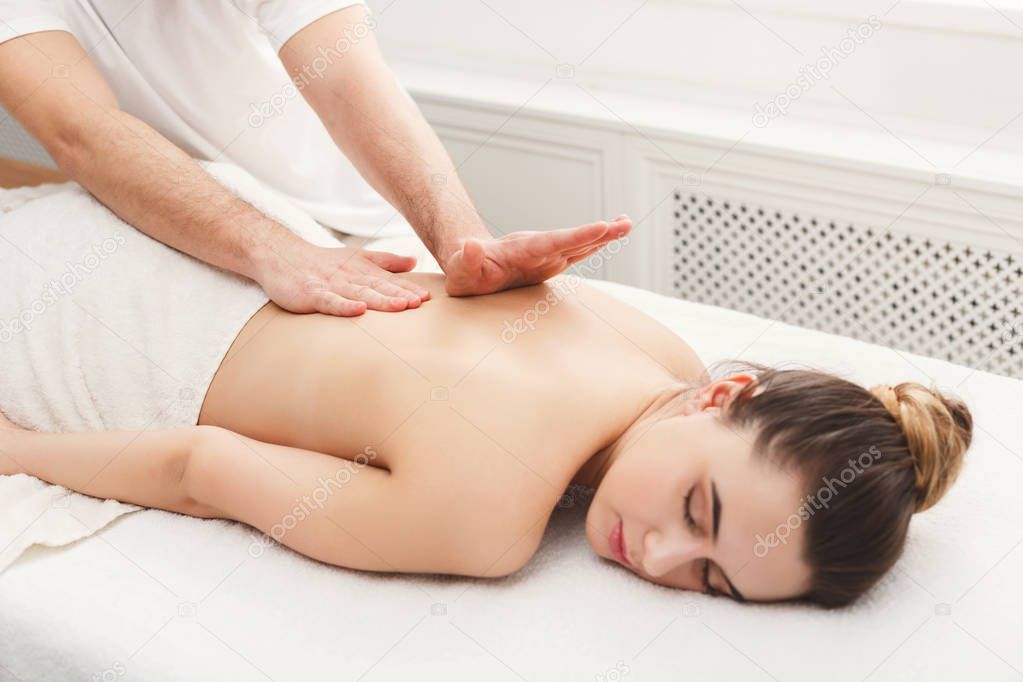 Closeup of hands massaging female back