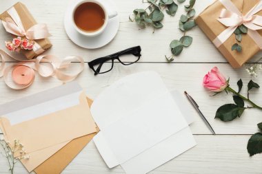 Düğün için davetiye ve Beyaz ahşap masa, zarflara