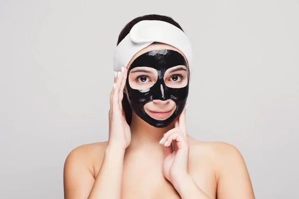 Young girl with purifying black face mask — Stock Photo, Image
