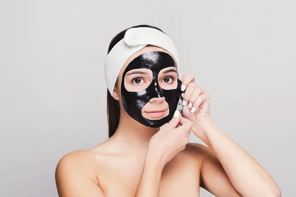 Young girl with purifying black face mask — Stock Photo, Image