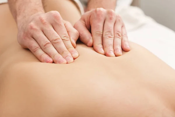 Primer plano de las manos masajeando la espalda femenina — Foto de Stock