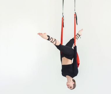 Beyaz arka plan üzerinde sinek yoga uygulamak kadın