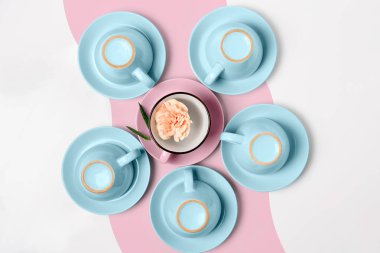 Elegant porcelain blue and pink cups turned upside down on abstract background clipart