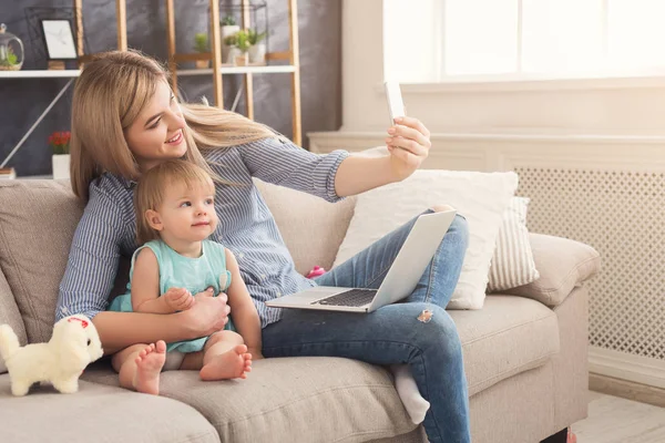 Jeune mère travaillant et passant du temps avec bébé — Photo