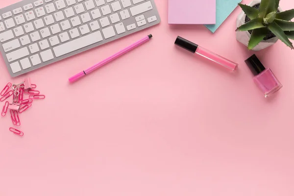 Рабочее место с клавиатурой на розовом фоне — стоковое фото