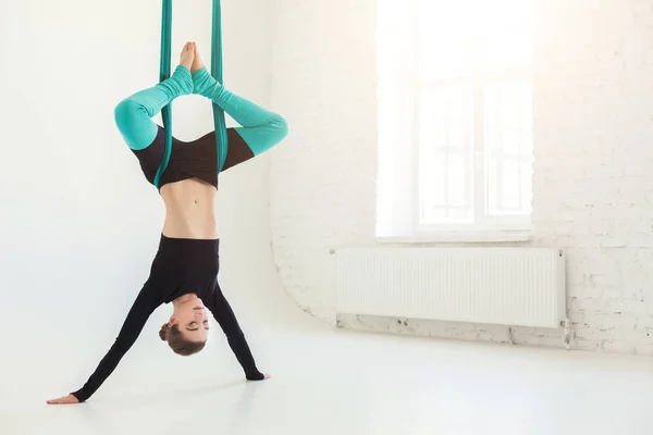 Woman practicing fly yoga over white background