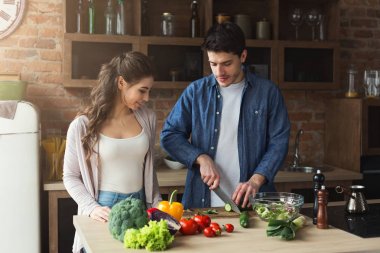 Mutlu çift birlikte yemek pişiriyor.