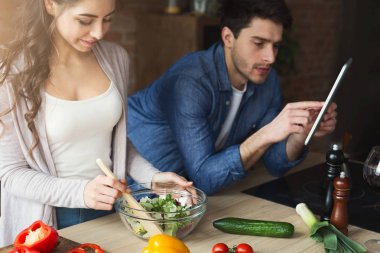 Mutlu çift birlikte yemek pişiriyor.