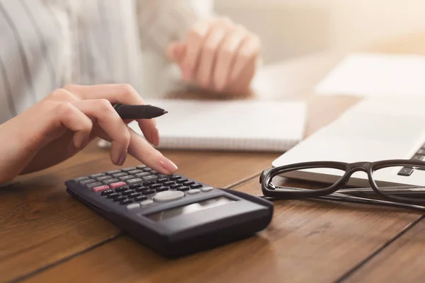 Primer plano de las manos de la mujer contando con la calculadora — Foto de Stock