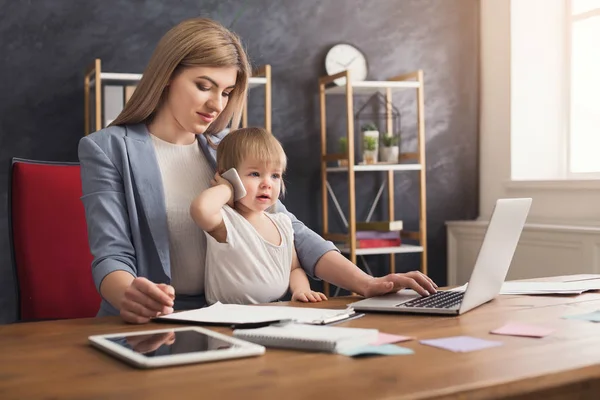 Joven madre trabajadora pasando tiempo con el bebé — Foto de Stock