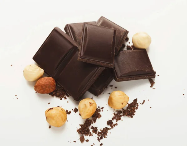Gebrochene dunkle Schokolade und Haselnuss isoliert auf weiß — Stockfoto