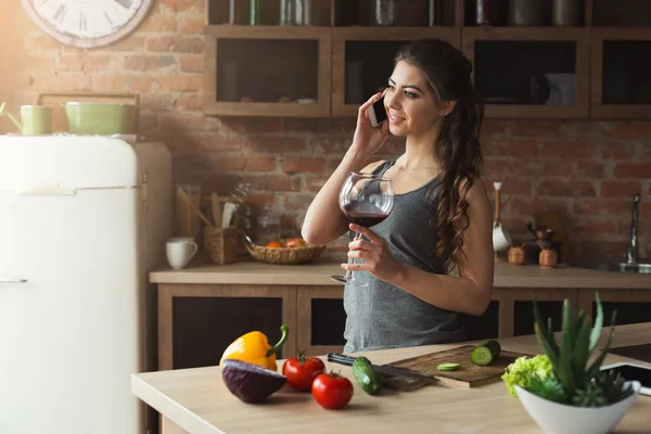 Happy woman talking on phone in the home kitchen — Stock Photo, Image
