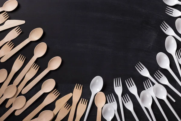 Environmentally friendly wooden cutlery vs plastic soons and forks — Stock Photo, Image