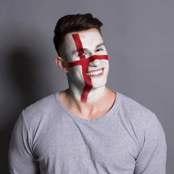 Young man with England flag painted on his face