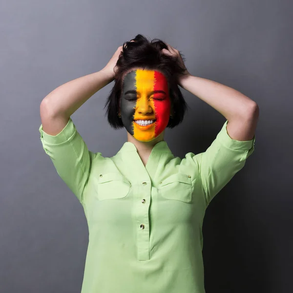 Giovane donna con bandiera belga dipinta sul viso — Foto Stock