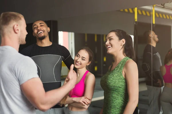 Group of sporty people talking at gym