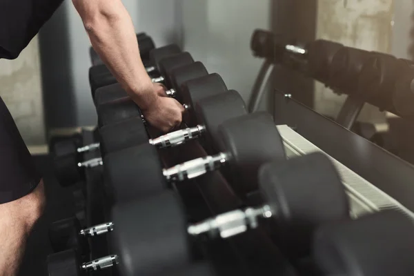 Hombre irreconocible tomando pesas en el gimnasio —  Fotos de Stock