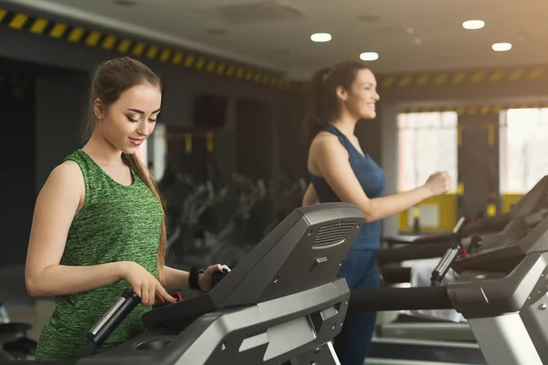 Donna attraente sul tapis roulant nel fitness club — Foto Stock