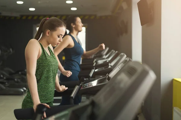 Mujer atractiva en la cinta de correr en el gimnasio — Foto de Stock