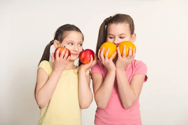 Muito bonito meninas com frutas sobre fundo branco — Fotografia de Stock