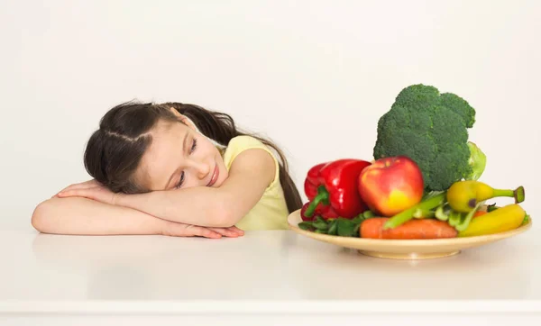 Мила дівчинка дивиться на свіжі овочі — стокове фото