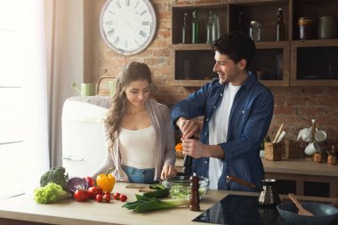 Mutlu çift birlikte yemek pişiriyor.