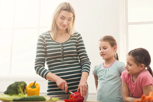 Szép nő, a lánya főzés saláta — Stock Fotó