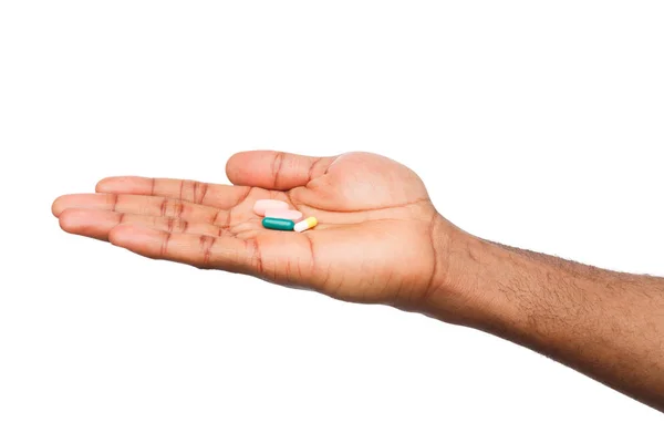 Mão segurando uma pílula isolada no fundo branco — Fotografia de Stock