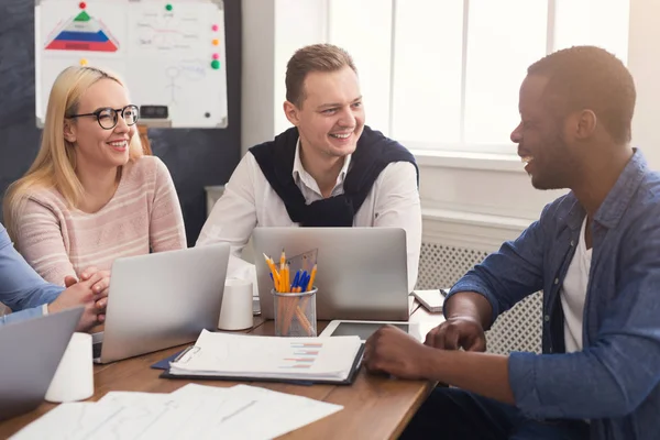 Jeune équipe discutant du projet dans un bureau moderne — Photo