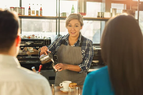 Hermoso barista sonriente haciendo café a los clientes —  Fotos de Stock