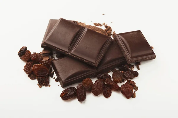 Zerbrochene dunkle Schokolade und Rosinen isoliert — Stockfoto