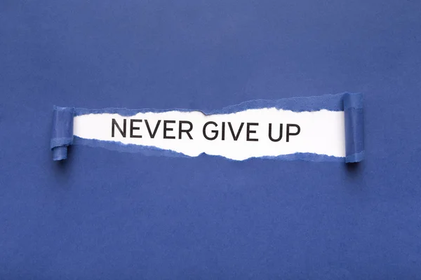 Nunca desista da frase estourando do papel azul rasgado — Fotografia de Stock