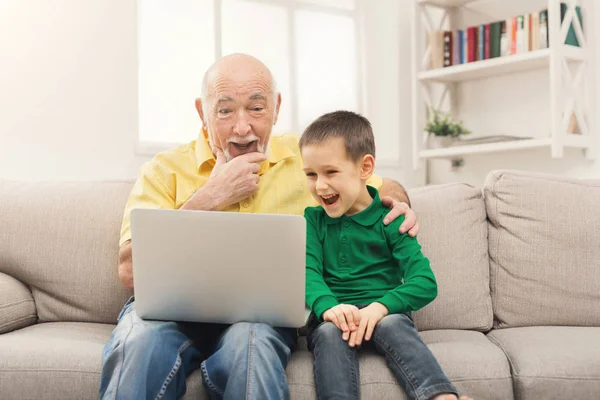 Маленький мальчик учит своего дедушку пользоваться ноутбуком — стоковое фото