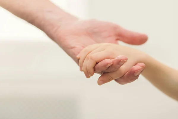 Grandfather holding hand of his grandchild closeup — Stock Photo, Image