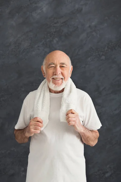 Веселий старший чоловік у спортивному одязі з рушником — стокове фото