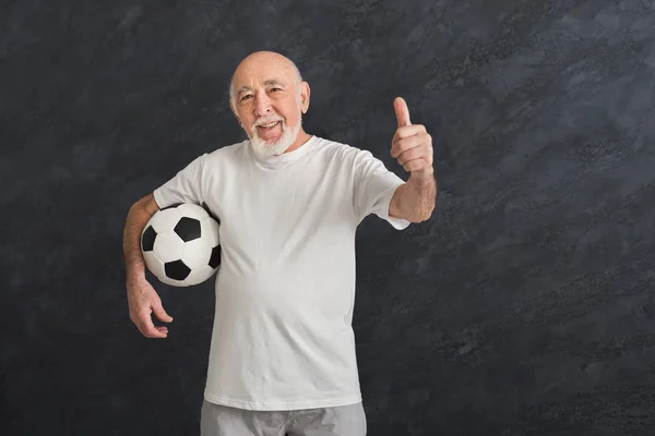 Uomo anziano con pallone da calcio mostrando pollice in su — Foto Stock